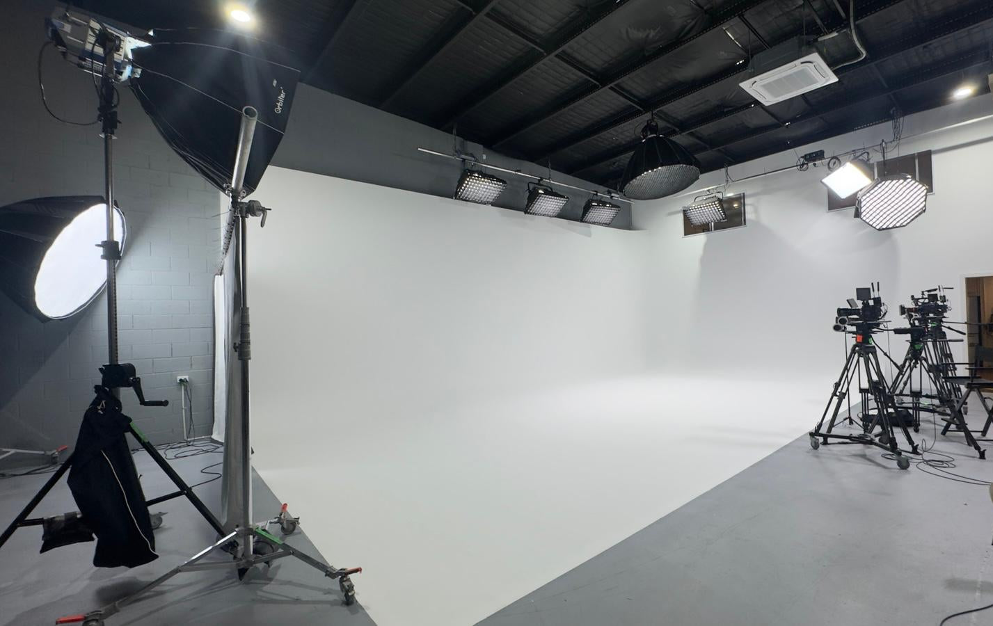 Studio setup with lighting equipment and cameras on a white background